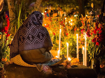 Mujer celebra el Día de Muertos en un cementerio de Oaxaca, México