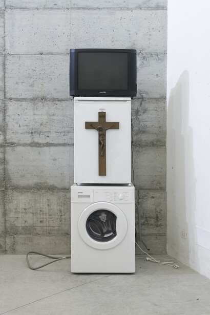 Danh Võ, Oma Totem, 2009, Phillips 26 inch TV, Goenje washing machine, Bomann, refrigerator, wooden crucifix, Nguyen Thi Ty’s personalized
entrance card for a casino