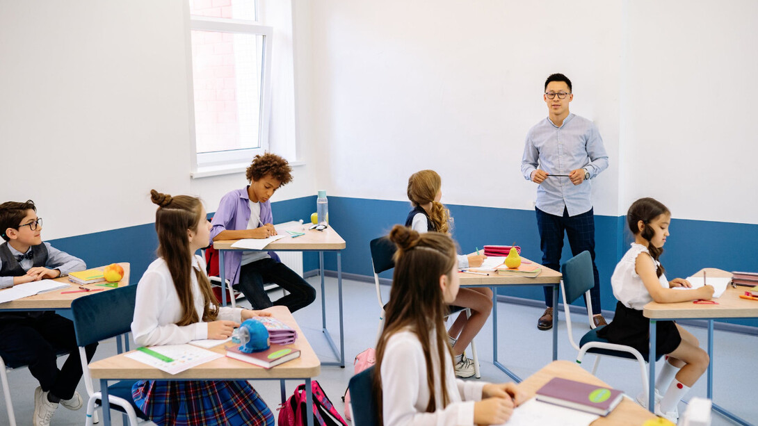 Insegnante spiega la lezione agli alunni mentre loro prendono gli appunti