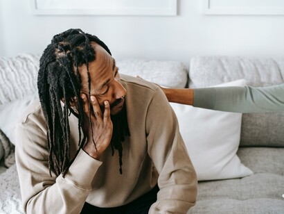 A man sitting on a sofa in a sweatshirt 