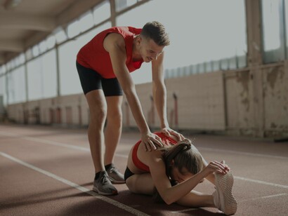 A couple helping each other stretch before they begin their workout