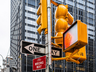 One-way and no-turn traffic signs on a Manhattan street, reflecting urban semiotics and city navigation systems in the USA