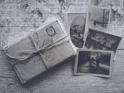 Lettere su una scrivania vicino a delle vecchie polaroid 