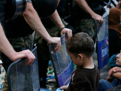 Una niña siria espera en la frontera griega con Macedonia