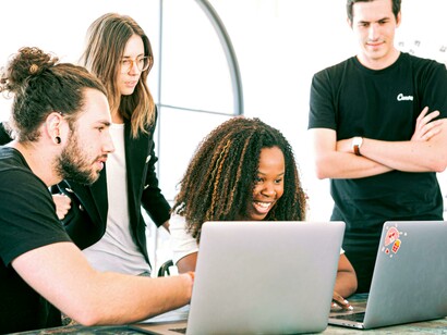Startup founders discussing ideas in an office setting, working on laptops