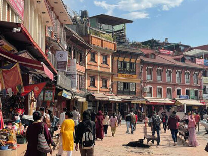 Mall Road in Manali, Himachal Pradesh, India, teeming with activity as locals and tourists stroll along the busy street, enjoying the lively atmosphere and picturesque surroundings