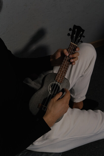 A man playing a small guitar, taking on a hobby, will help your mental well being