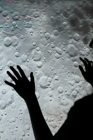 A woman examines a picture of the moon's surface