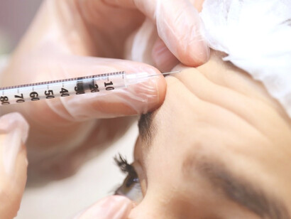 A woman receiving botox treatment from a doctor