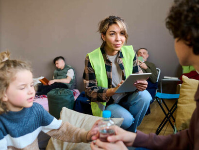 A young female volunteer helps refugees at the shelter