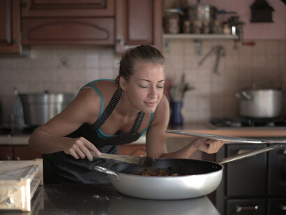 A woman savoring the smell of freshly prepared food, capturing the essence of cooking and food experience