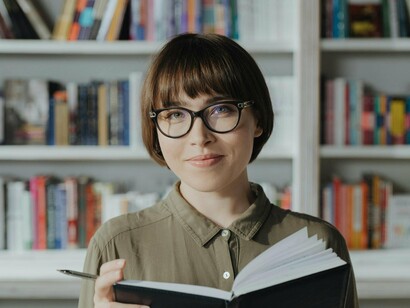 Mulher lê em biblioteca. Tem gente que começa a gostar de leitura com gibis. E, quer saber? Isso é maravilhoso! Quem nunca se apaixonou pelas aventuras do Tio Patinhas ou do Homem-Aranha? Gibis são uma porta de entrada fantástica para o mundo da leitura, principalmente para crianças e adolescentes


