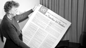 Eleanor Roosevelt sosteniendo una copia en español de la Declaración universal de los derechos humanos, en la cual influyó Maritain