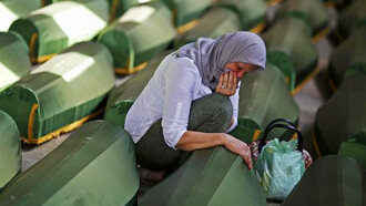 A women crying before a coffin