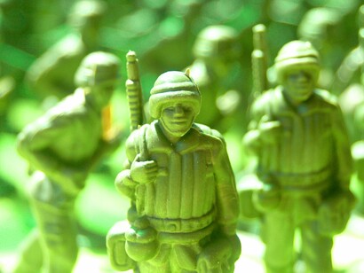 A cluster of plastic toy soldiers, reflecting the reduction of human lives to expendable pieces in distant conflicts