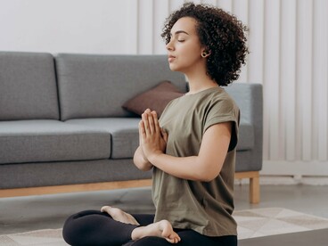 Sentada no chão, a mulher permanece em uma posição de yoga, voltada para um momento de concentração. A meditação é apresentada no artigo como uma possibilidade de acessar novos estados internos e transformar a maneira de experimentar a realidade