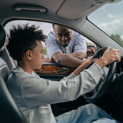 Momentos de aprendizado capturados entre pai e filho dentro de um automóvel dos sonhos, refletindo sobre o valor de cultivar sonhos e compartilhar conhecimento