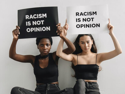 Black and Asian women, joining hands in solidarity, stand together against racism and marginalization