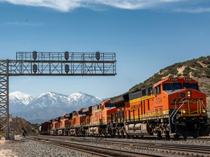A freight locomotive hauling a long cargo line through a mountain area, reflecting the value of resilient logistics networks