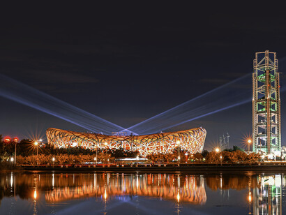 The Beijing National Stadium glowing at night. Designed for the 2008 Olympics by Herzog & de Meuron, the building’s interwoven steel structure resembles a bird’s nest and represents a notable example of biomimicry in contemporary architecture, Beijing, China