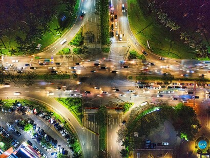 An urban intersection carrying streams of traffic in multiple directions, representing the interconnected flows that sustain modern societies and economies