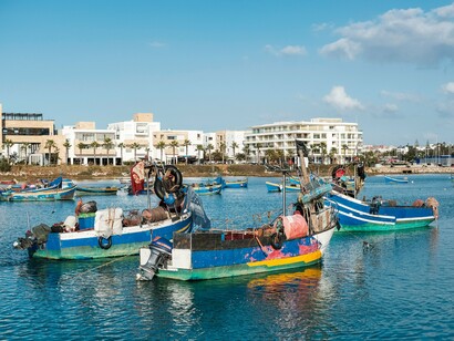 Colorful fishing boats along the Bouregreg waterfront, symbolising the historic river that inspired the Grand Theatre’s flowing architectural form