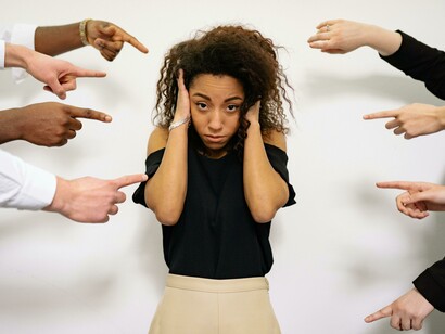 In a hostile digital landscape, a woman faces public shaming and isolation—reflecting the pervasive threats of hate speech and cyberbullying that challenge the very foundation of digital dignity