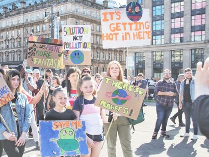Children in Glasgow, Scotland holding signs and pleading the government to save their environment