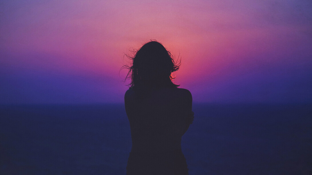 Mujer en la playa recordando un amor pasado durante la puesta de sol. Nadie nunca me enseñó qué hacer, cuando se te rompe el corazón