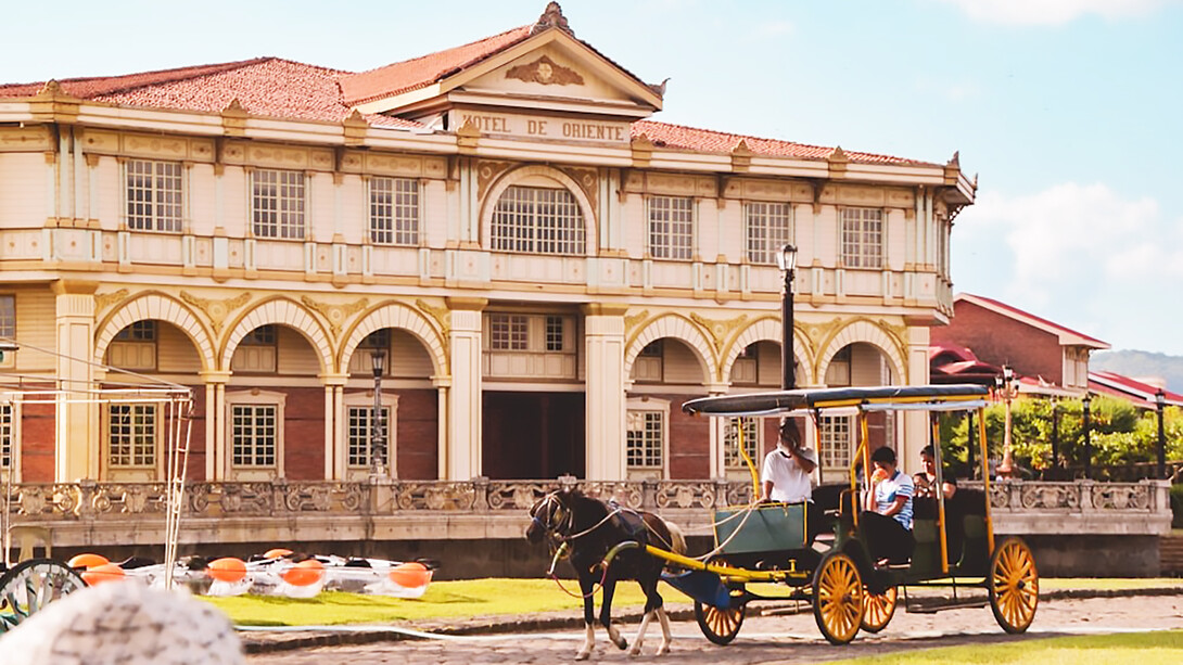 Vibrant yellow and green Kalesa captured against the backdrop of Las Casas in Bagac, Philippines, showcasing the traditional charm and cultural heritage of this iconic mode of transportation