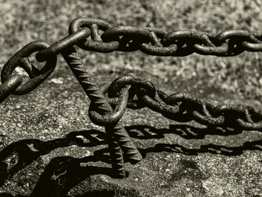 Rusted chains pierced by a sharp spike symbolize the violence used to maintain slavery, enforcing a hierarchy that protected elite wealth and suppressed resistance
