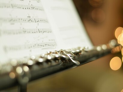 Flauto traverso con spartito: “Da flautista, mi è sempre piaciuto sperimentare gli armonici, quei suoni puri che si ottengono soffiando con tecniche particolari sullo strumento. Questi suoni sono un’espressione diretta delle leggi fisiche e matematiche del suono, e ascoltarli è come sentire la matematica prendere vita”