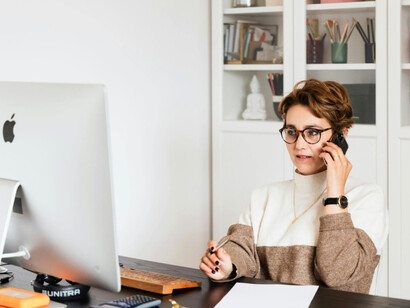 A businesswoman handling communication and tasks simultaneously, signifying the importance of intentional listening in busy workplaces