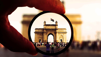 Person holding a round lens in Mumbai, India