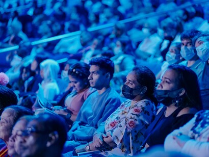 Blue light illuminates the audience in the theatre
