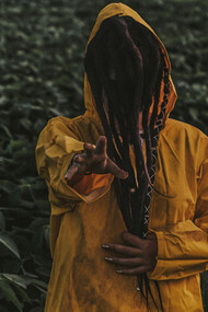 A man in yellow reaching for the viewer, reminiscent of a terrible King who wore the same color