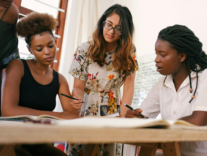 A group of women in an office discussing upcoming issues