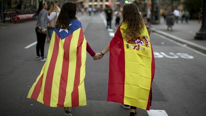 Dos jóvenes se dan la mano en una calle de Barcelona durante las protestas del 3 de octubre por las cargas del 1-O