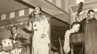 Billie Holiday performs live at Club Bali in Washington, D.C. (September 1948) alongside Al Dunn and Bobby Tucker—capturing the powerful, immediate stage presence that audiences celebrated while often disconnecting her music from the ongoing struggles of her daily life