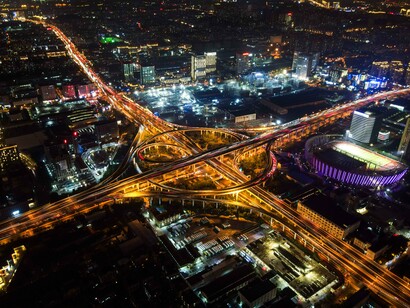 A vast network of intersecting highways cutting through a modern metropolis, symbolizing the complexity of today's interconnected digital economy