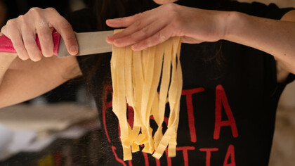 La résistance se savoure : dans La Pastasciutta antifascista, chaque geste compte. Ici, les bras d’une interprète révèlent les spaghettis fraîchement coupés, symbole d’un acte quotidien devenu acte de liberté et de partage