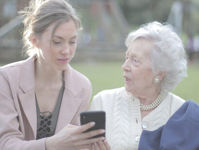 A cheerful senior mother and her adult daughter bonding over a smartphone