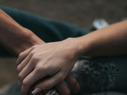 Two people hold hands