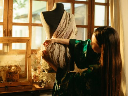 A designer carefully adjusting fabric on a mannequin, representing the art of creating clothes that work with the body rather than conceal it