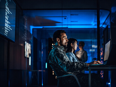 Military and civilian personnel working together in a high-tech cybersecurity command center