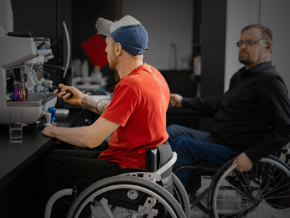 An inclusive coffee shop where people using wheelchairs work together, reflecting disability inclusion in the workplace