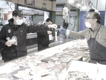 Esta imagen es de la plaza de abastos de una ciudad española: la policía repartiendo mascarillas