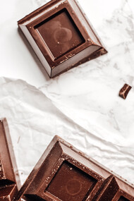 Barra de chocolate quebrada em quadradinhos sob a mesa