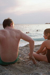 Atores principais do filme Aftersun interpretando pai e filha em um diálogo na praia