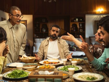 An emotional family conflict takes place at the dinner table during an indoor gathering